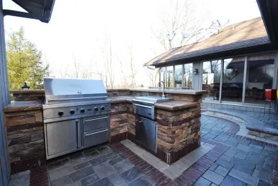 Tailored Outdoor Cooking Area with Elevated Patio and Personalized Garage Flooring — Landscape Design project by Stonewood And Waters