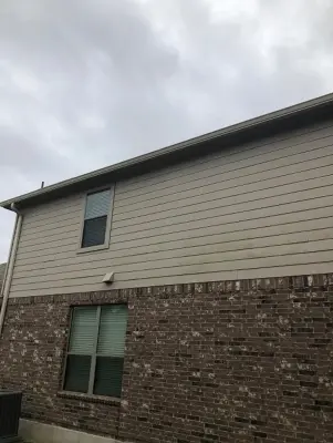Beige Split Level Home Gutter Installation in Buda, TX by Gutter Tex