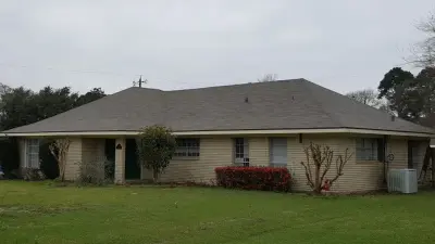 Tan Brick House - Shingle Roof — Roofing & Gutter Services project by Roofing Louisiana